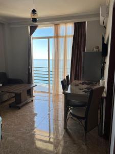 - un salon avec une table et une vue sur l'océan dans l'établissement Tiko's Apartments, à Gonio