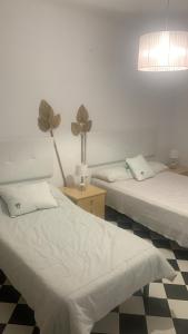 ein Zimmer mit zwei Betten und einem Tisch mit einer Lampe in der Unterkunft ALOJAMIENTO RURAL CASA LOS ARENALES in Córdoba