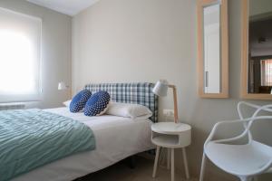 1 dormitorio con cama, espejo y silla en Apartaments Turístics Cardona II, en Cardona