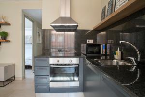 una cocina con fregadero y estufa horno superior en Apartaments Turístics Cardona II, en Cardona