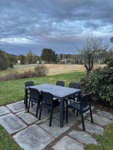 a table and chairs on a patio with a field at Skogro ved Norefjell in Noresund