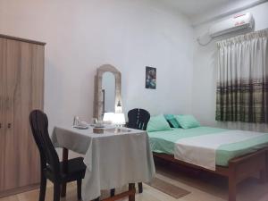 a bedroom with a bed and a table and chairs at CANAAN MUSIC Hotel in Moratuwa