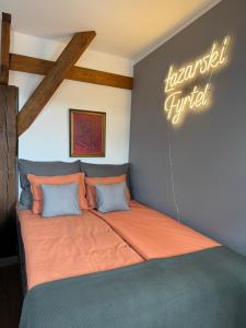 a large bed in a room with a sign on the wall at Apartament Fyrtel in Poznań