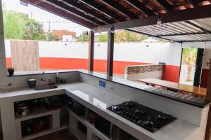 a kitchen with a counter top with a stove at Recanto dos Pássaros Refúgio com piscina e lazer in Pôrto Feliz