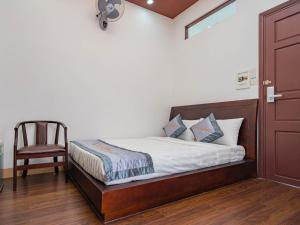a bedroom with a bed and a chair and a door at Sontra Sea Hotel in Danang