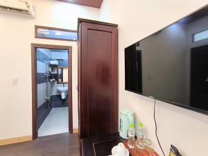 a room with a television and a bathroom with a toilet at Sontra Sea Hotel in Danang