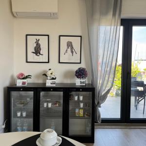 a room with a black cabinet with pictures on the wall at Villa Angelina in Aquino