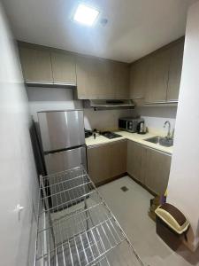 a small kitchen with a sink and a refrigerator at Makati City Serenity Tower 2501 in Manila