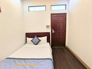 a small bedroom with a bed and a door at Sontra Sea Hotel in Danang