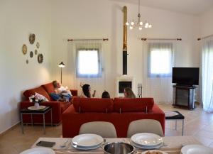 a family sitting on a couch in a living room at Villa Asteria in Samothraki