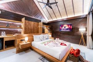 a bedroom with a bed and a tv in a room at Villa Bolon in Kuta