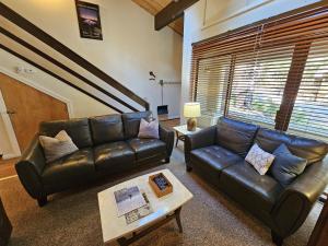 Sala de estar con 2 sofás de cuero y mesa de centro en Cartwright Corner Condo townhouse, en Incline Village