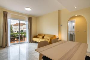 ein Wohnzimmer mit Sofa und Tisch in der Unterkunft Vista Hermosa by H - Costa Esuri EVHH167P00 in Ayamonte