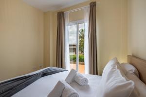 ein Schlafzimmer mit einem Bett und einem großen Fenster in der Unterkunft Vista Hermosa by H - Costa Esuri EVHH167P00 in Ayamonte + 26 Fotos