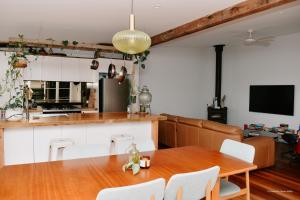 a kitchen and dining room with a wooden table at Evans Head Beach House - Entertainer in Evans Head