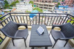 a balcony with two chairs and a table with a laptop at Pokhara Crown Plaza in Pokhara