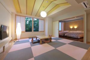 a bedroom with a bed and a checkerboard floor at Kusatsu Skyland Hotel in Kusatsu