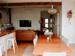 a living room with a wooden table and a couch at Evans Head Beach House - Entertainer in Evans Head