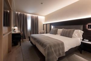um quarto de hotel com uma cama grande e uma escrivaninha em Hotel Màgic Pas em Pas de la Casa