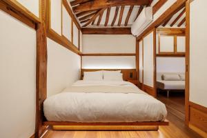 ein Schlafzimmer mit einem Bett in einem Zimmer mit Holzdecken in der Unterkunft Full moon hanok - Premium stay , Open sale in Seoul