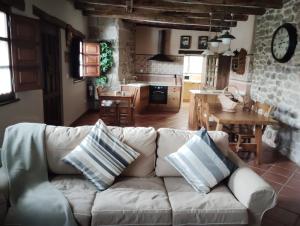 a living room with a white couch and a kitchen at El Limonero in Arenas de Iguña