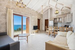 sala de estar y cocina con vistas al océano en Milos Paradise Luxury Villas, en Agios Nikitas