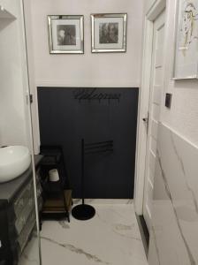 a bathroom with a sink and a black wall at Oaza Spokoju in Szczawno-Zdrój +2 photos
