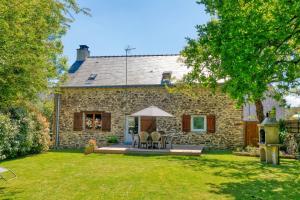 a stone house with a patio in the yard at Maison avec grand jardin 10km plage in Férel