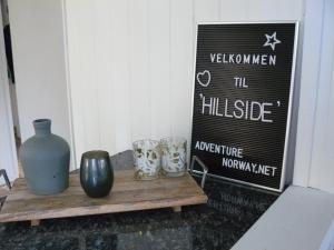 a table with vases and cups on it with a sign at Hillside - Adventure Norway in Bjelland