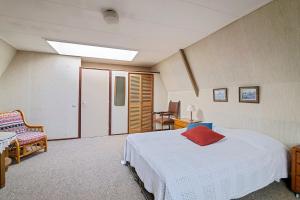 a bedroom with a white bed and a chair at Authentic sleeping in the city center in Leeuwarden