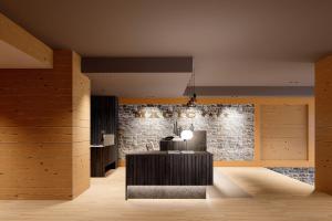uma sala de estar com uma parede de pedra e uma mesa em Hotel Màgic Pas em Pas de la Casa