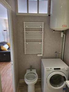 a small bathroom with a toilet and a washing machine at Appartement au coeur de Saumur - Chambre climatisée in Saumur +5 photos