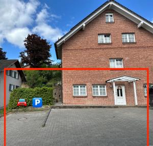 a large brick building with a parking lot in front of it at Ferienwohnung in Ruppichteroth Winterscheid im EG mit Garten und Klima in Ruppichteroth