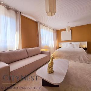 a hotel room with a bed and a couch at Studio Premium CityNest in Strasbourg