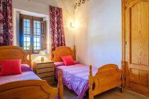 Un dormitorio con dos camas y una ventana. en Villa El Encanto, Ideal For Families And Groups, en Sant Miquel de Balansat