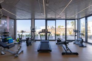 a gym with treadmills and cardio machines in a room with windows at Radisson Blu Resort, Lanzarote Adults Only in Costa Teguise