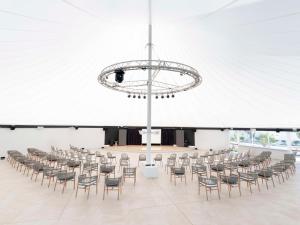 a large room with rows of chairs and a chandelier at Radisson Blu Resort, Lanzarote Adults Only in Costa Teguise
