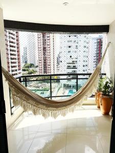 a hammock in a room with a large window at Apto 3 quartos de requinte no centro de Belém in Belém
