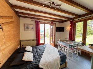 a bedroom with a bed and a table with chairs at LE NARCISSE in Crest-Voland