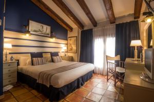a bedroom with a bed and a desk and a television at Hotel Abaco Altea in Altea