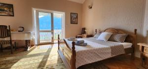 a bedroom with a bed and a large window at Lorena Rooms in Risan