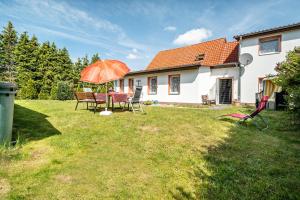 Un patio trasero con una mesa y sillas y una sombrilla. en Ferienwohnungen in Starsow, en Mirow