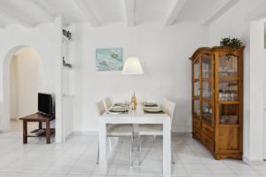 a white dining room with a white table and a cabinet at Nuestra Casa in Denia