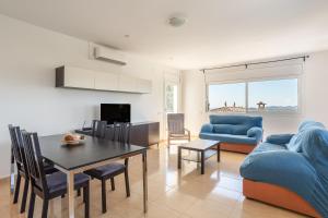 ein Wohnzimmer mit einem blauen Sofa und einem Tisch in der Unterkunft Azzure in Lloret de Mar