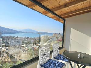 ein Raum mit Tisch und Stühlen und einem großen Fenster in der Unterkunft Villa Arta Apartments in Sarandë