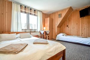 a bedroom with two beds and a large window at U Topora z Jacuzzi - 80m do stacji narciarskiej in Małe Ciche