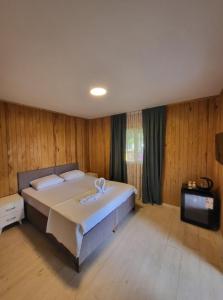 a bedroom with a large bed and a television at Çiçek Evler Tatil Köyü in Armutlu