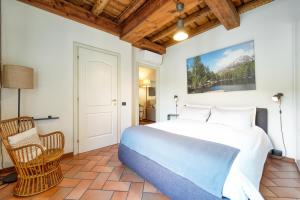 a bedroom with a large bed and a chair at CASA DI MILO in Cernobbio
