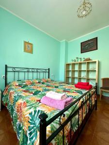 a bedroom with a bed with a colorful comforter at Casa Rosa in Toscolano Maderno