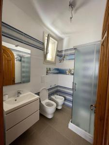 Un baño con dos inodoros, un lavabo y una ducha. en Casa aperanza, en Nápoles